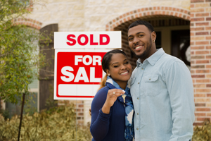 Young Couple in front of their new house.